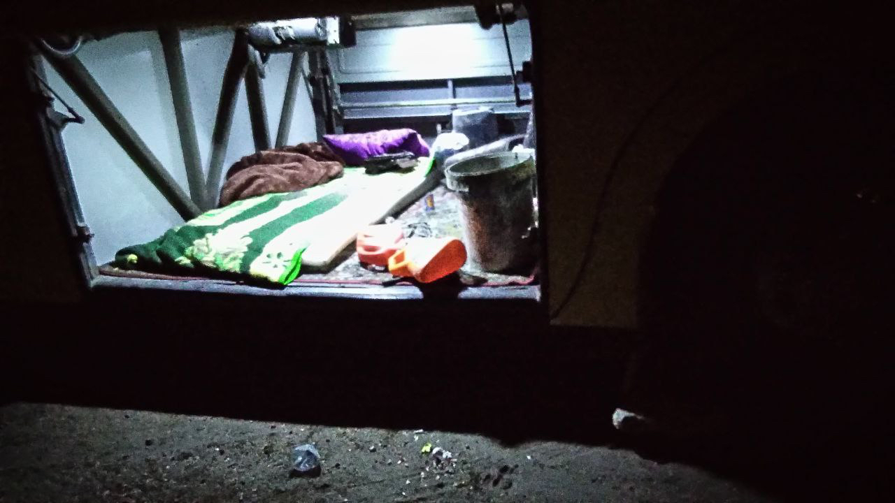The driver's bedding inside the open luggage compartment