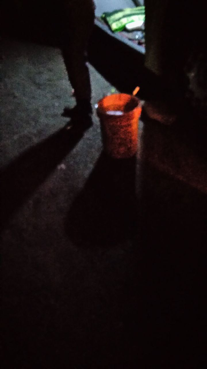An orange fuel container on the ground at night