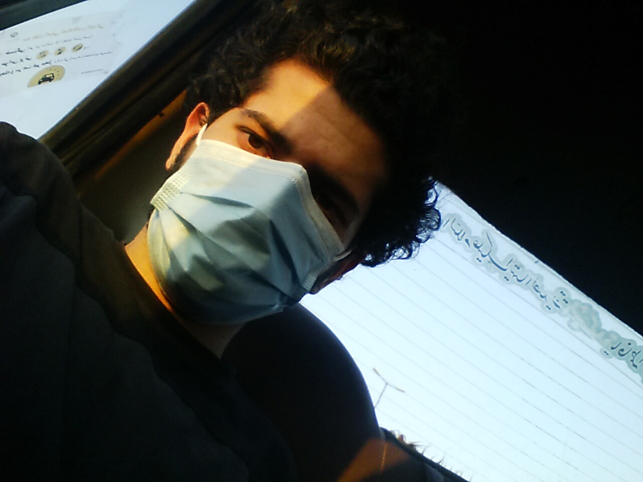Me in the back of the car at night, in a face mask